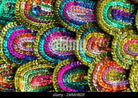 Beautiful multi-colored sequins shimmering in the light in the form of a peacock tail. Abstract background for design. Stock Photo