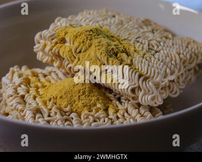 A bowl of noodles with a spoon on a table Stock Photo