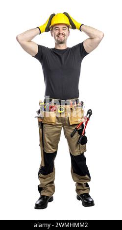 Smiling worker in hard hat and tool belt standing against a white background Stock Photo