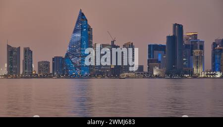 Doha, Qatar skyline from the corniche promenade at night with dhows and boats in the Arabic gulf Stock Photo