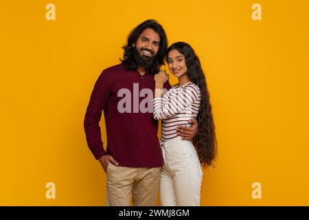 Beautiful millennial bearded man and long-haired woman on yellow Stock Photo