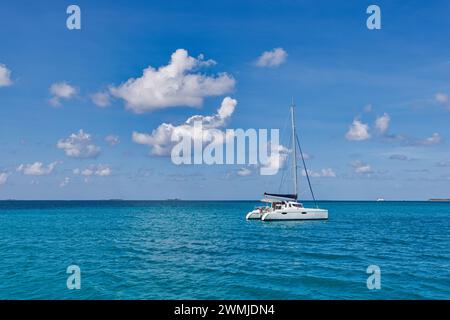 White sailing boat traveling in Maldives blue sea on a bright sunny summer day in the middle of nowhere. Tropical sea and sailing boat. No sails Stock Photo