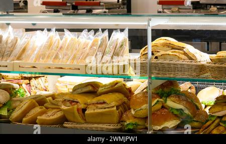 many Delicious sandwiches and filled rolls on sale in the display case of the train station bar Stock Photo