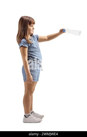 Full length profile shot of a little girl throwing a plastic bottle isolated on white background Stock Photo