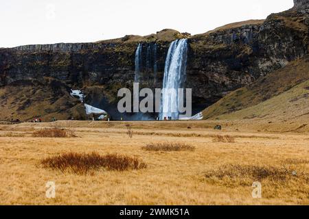 Spectacular waterfall in iceland with stream falling off hills, seljalandsfoss cascade with water flow. Majestic polar icelandic scenery and nordic wilderness, scandinavian frozen land. Stock Photo