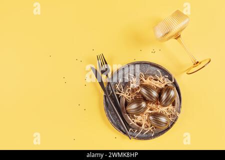 Table place setting and festive easter decor on yellow background Stock Photo