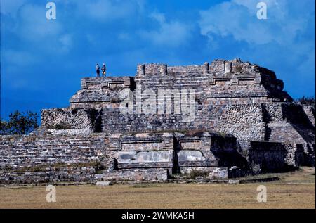 Tourists stand on the ruins of Monte Alban, a Zapotec capital. It is a large pre-Columbian archeological site including pyramids and terraces in th... Stock Photo
