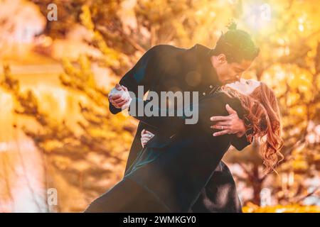 A mixed race couple kissing while dancing and spending quality time together during a fall family outing in a city park; Edmonton, Alberta, Canada Stock Photo