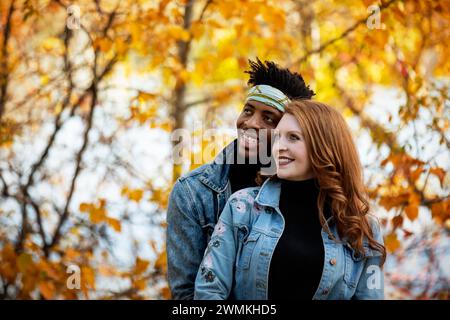 Close-up portrait of a mixed race married couple, embracing and enjoying the autumn colors while spending quality time together during a fall famil... Stock Photo