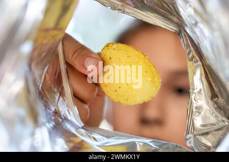 Crispy potato chips in aluminum metal bag package. The concept of an unhealthy food and lifestyle. Bag of Potato Chips inside pack view Stock Photo
