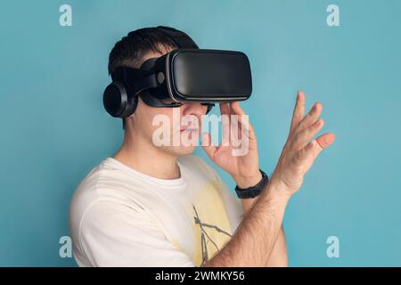 Happy man play vr eyeglasses on blue background, Stock Photo