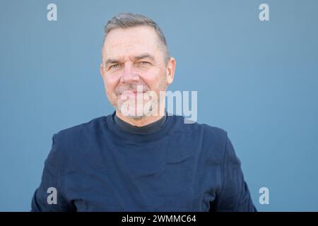 Close up portrait of a middle aged man looking friendly at the camera wearing a blue sweater Stock Photo