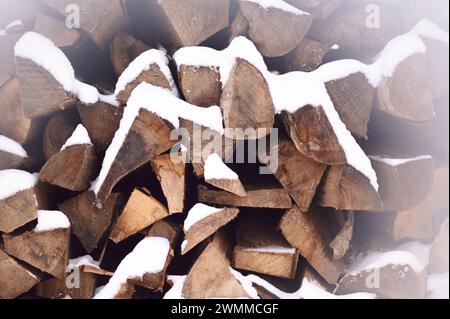 Snow-covered stack of firewood in winter Stock Photo