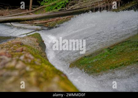 A river flowing over rocks and boulders below Stock Photo