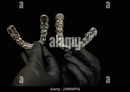 doctors hands in black gloves holding silicone mouth guard Stock Photo