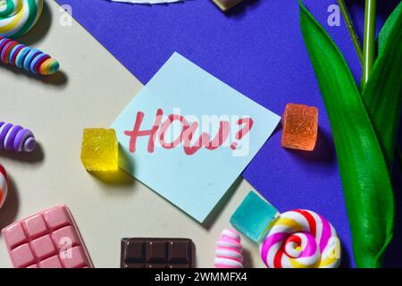 English vocabulary "HOW" on the theme of sweets, chocolate bars, lollipops, candy as a background Stock Photo