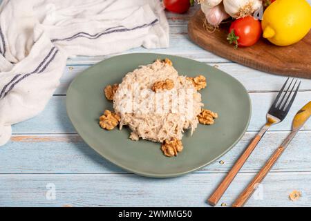 Circassian chicken dish. Appetizer dishes. Salad with flour, walnuts and chicken on a blue wooden background. local name çerkez tavuğu Stock Photo