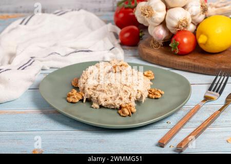 Circassian chicken dish. Appetizer dishes. Salad with flour, walnuts and chicken on a blue wooden background. local name çerkez tavuğu Stock Photo