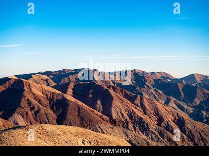 Desolate Badlands with jagged mountains as seen from Dante's Peak in Death Valley National Park lit by waning sunset light Stock Photo