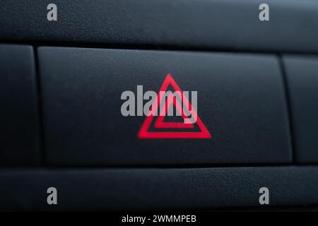 Hazard light indicator on car dashboard, shallow depth of field Stock Photo