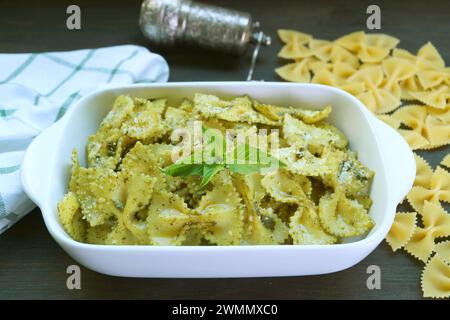 Delectable Homemade Farfalle Pasta with Pesto Sauce on Kitchen Table Stock Photo