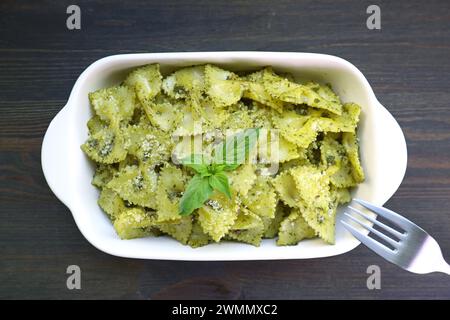 Homemade Farfalle Pasta with Pesto Sauce Isolated on Wooden Table Stock Photo