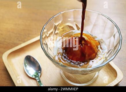 Vanilla ice cream being poured with a shot of espresso for a cup of Affogato Stock Photo