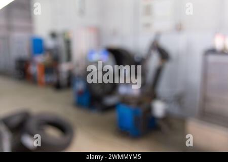 Blurred image inside tire service center. Replacing rubber on car wheels. Wheel balancing. Car tire service center auto repair workshop blurred backgr Stock Photo