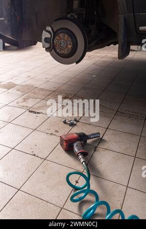 Hydraulic car jack lift the new car for change the tyre. Seasonal tyre change or service abstract concept. Stock Photo