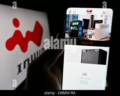 Person holding cellphone with webpage of Taiwanese computer hardware company InWin Development Inc. with logo. Focus on center of phone display. Stock Photo