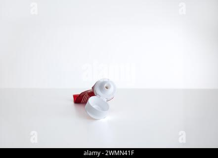 Rolled and squeezed out empty plastic toothpaste tube, isolated on white, close up shot. Stock Photo