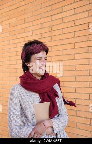 Portrait of young female student holding books or notebooks outdoors. world book day Stock Photo