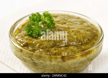 Closeup of basil pesto in glass bowl Stock Photo