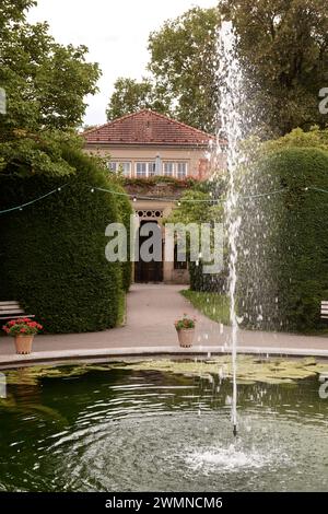 Tranquil Park Oasis: Fountain Amidst Scenic Landscapes. Urban Oasis- Majestic Fountain Amidst Lush Parkland. Splendid Fountain Gracing City Park Stock Photo