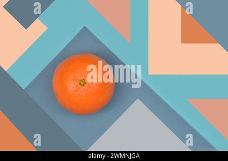 Abstraction - food is art, mixed media: mandarin on background full of triangles, blue, orange, peach colors. Stock Photo