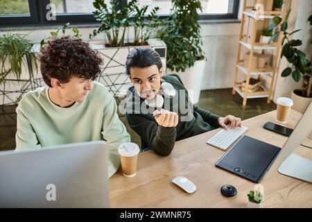Coworkers collaborating on retouching tasks in post-production office, men in 20s creating startup Stock Photo
