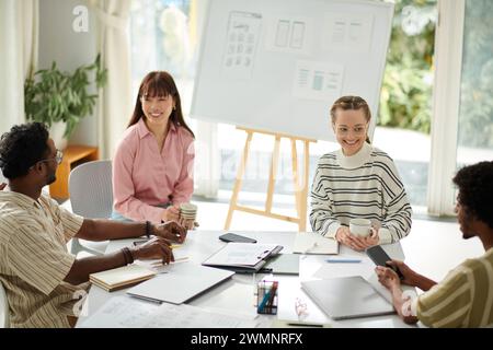 Creative team chatting and discussing news before daily standup meeting Stock Photo