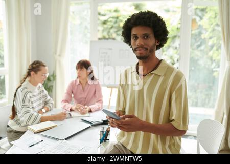 Portrait of Black man testing new mobile application his colleagues created Stock Photo