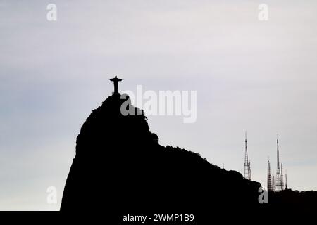 sun setting behind the statue of Christ the Redeemer in Rio de Janeiro, Brazil - October 16, 2023: sunset seen from the Urca neighborhood in Rio de Ja Stock Photo
