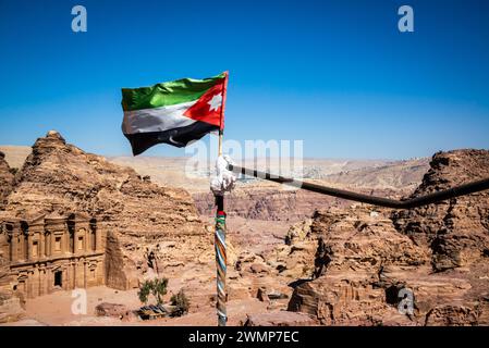 Jordanian flag blowing in the wind with the building known as the Monastery in the background in Petra, Jordan Stock Photo