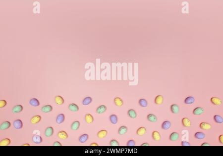 Top view of colourful easter eggs on pink background. Creative easter composition, spring, copy space, flat lay. Stock Photo