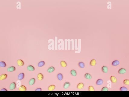 Top view of colourful easter eggs on pink background. Creative easter composition, spring, copy space, flat lay. Stock Photo