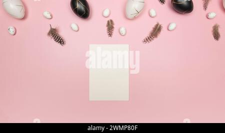Top view of easter eggs, feathers, white card on pink background. Creative easter composition, spring, flat lay, copy space. Stock Photo