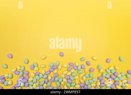Top view of colourful easter eggs on yellow background. Creative easter composition, spring, copy space, flat lay. Stock Photo