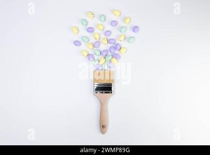 Top view of colourful easter eggs, paint brush on white background. Creative easter composition, spring, flat lay, copy space. Stock Photo