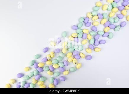 Top view of colourful easter eggs on white background. Creative easter composition, spring, copy space, flat lay. Stock Photo