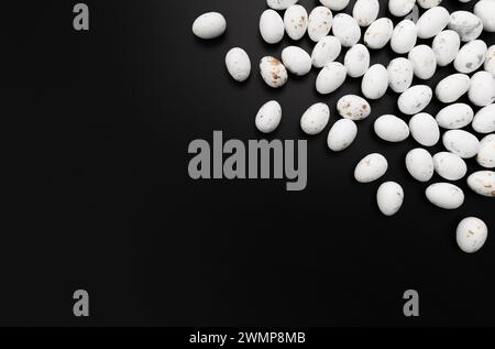 Top view of white easter eggs on black background. Creative easter composition, spring, copy space, flat lay. Stock Photo