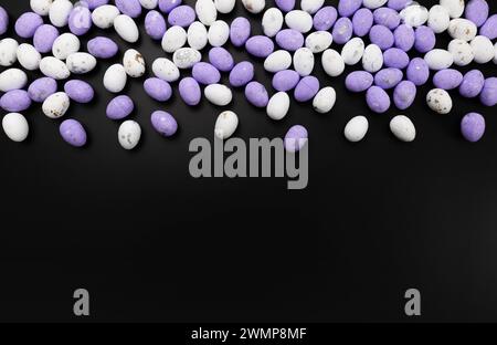 Top view of purple and white easter eggs on black background. Creative easter composition, spring, copy space, flat lay. Stock Photo