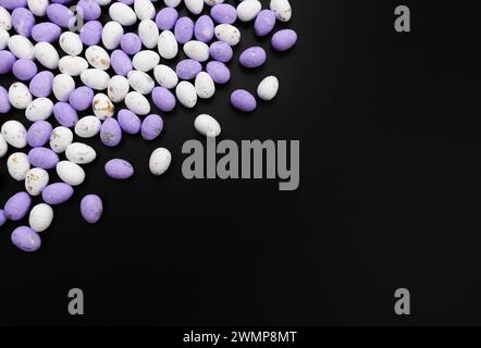 Top view of purple and white easter eggs on black background. Creative easter composition, spring, copy space, flat lay. Stock Photo