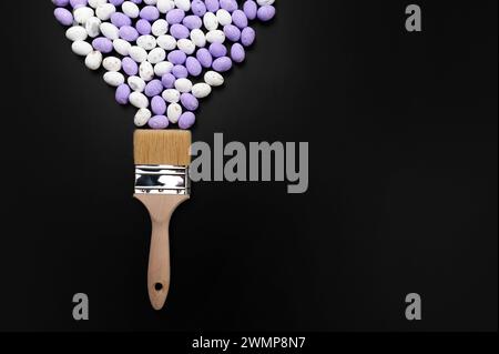 Top view of white and purple easter eggs, paint brush on black background. Creative easter composition, spring, flat lay, copy space. Stock Photo